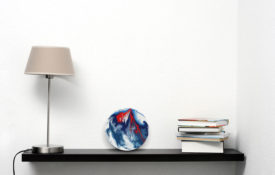 Red and Blue Art on Shelf With Lamp and Books